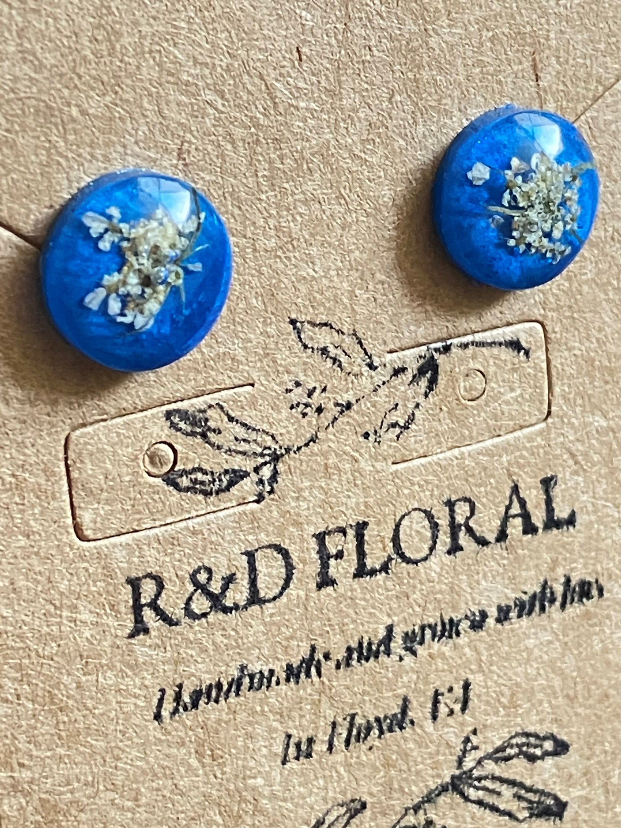 Blue resin stud earrings encasing real Queen Anne’s Lace flowers handmade by R&D Floral.